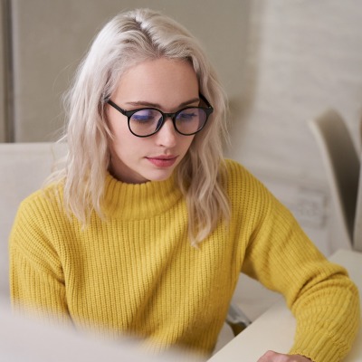 Fashion shot of a woman in a yellow knit sweater and glasses. By Nick van der Touw.