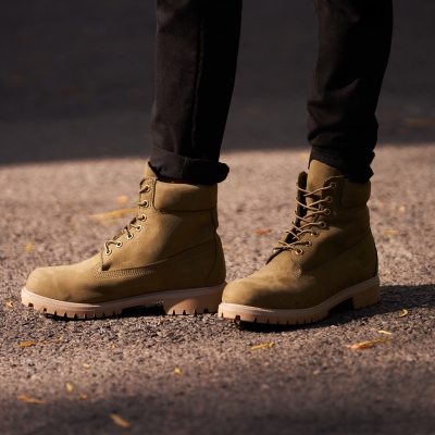 Footwear shot of tan work boots on the ground. By Nick van der Touw.