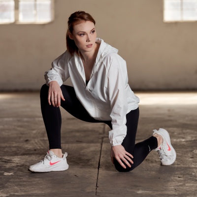 Athleisure shot of a woman crouching in a white shirt and black leggings. By Nick van der Touw.