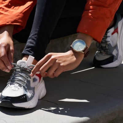 Footwear shot of hands lacing white sneakers. By Nick van der Touw.