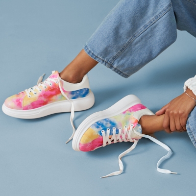 Product shot of colourful sneakers on a yellow line. By Nick van der Touw.