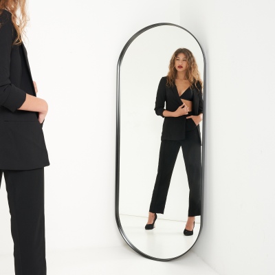 Fashion shot of a woman in a black blazer suit at a mirror. By Nick van der Touw.