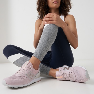 Activewear shot of a woman in grey leggings and pink sneakers. By Nick van der Touw.
