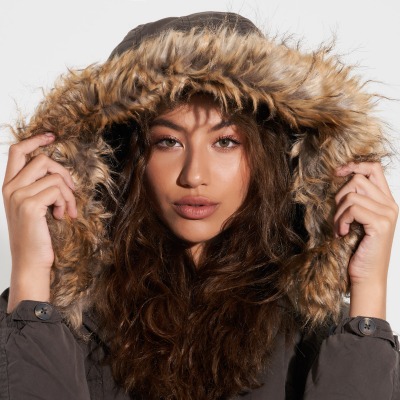 Fashion shot of a woman in a brown fur-trim hood. By Nick van der Touw.