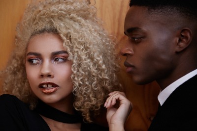 Editorial portrait of a couple framed close, with glitter lip styling. By Nick van der Touw.