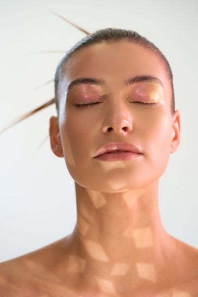 Serene beauty close-up of Albina with bronzed skin and soft dappled light. Studio editorial by Nick van der Touw.