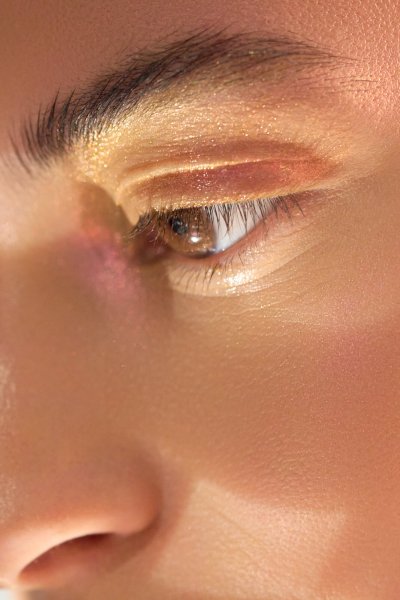 Macro beauty close-up of Albina's eye in gold and copper eyeshadow. Studio editorial by Nick van der Touw.