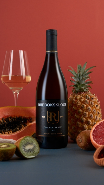 Rhebokskloof Chenin Blanc with white wine and pineapple on a red backdrop. By Nick van der Touw.