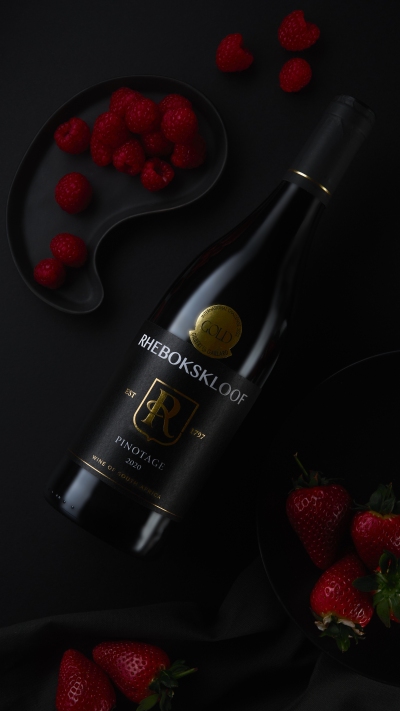 Rhebokskloof Pinotage bottle in dark studio light. By Nick van der Touw.