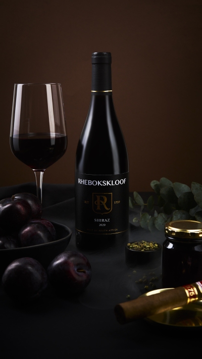 Rhebokskloof Shiraz bottle with a glass of red wine and eucalyptus. By Nick van der Touw.
