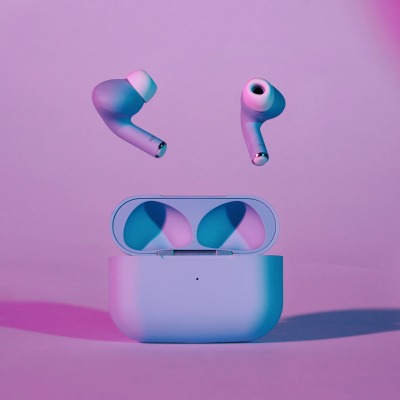 Product shot of pink and white wireless earbuds. By Nick van der Touw.