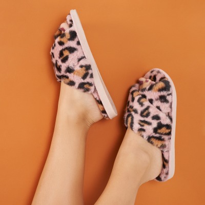 Product shot of leopard-print and tan slide sandals. By Nick van der Touw.