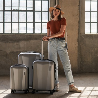 Travel shot of a model with a set of wheeled suitcases. By Nick van der Touw.