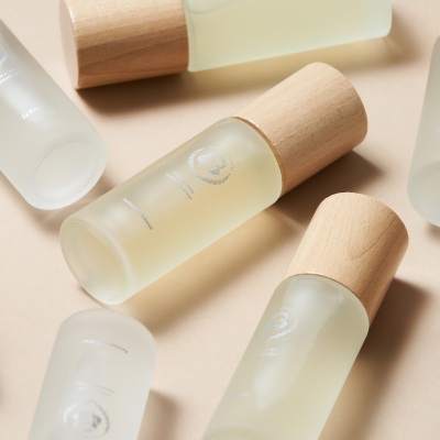 Skincare product shot of frosted-glass bottles with wood caps. By Nick van der Touw.