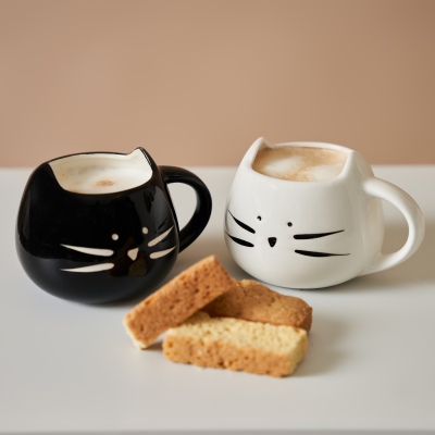 Lifestyle shot of cat-shaped mugs with coffee and toast. By Nick van der Touw.