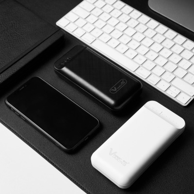 Product shot of black power banks beside a keyboard. By Nick van der Touw.