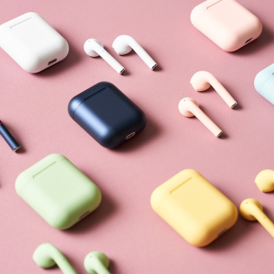 Product shot of navy wireless earbuds with a charging case. By Nick van der Touw.