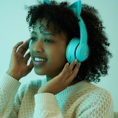Lifestyle shot of a woman in mint headphones. By Nick van der Touw.