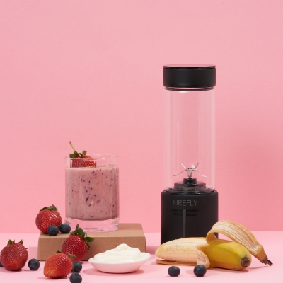 Lifestyle shot of a portable blender with a smoothie on pink. By Nick van der Touw.
