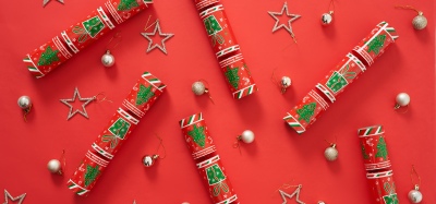 Festive flat lay of Christmas crackers on a red backdrop. By Nick van der Touw.
