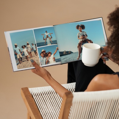 Lifestyle shot of hands holding a printed photo book. By Nick van der Touw.