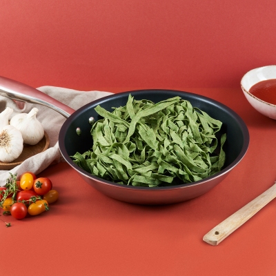 Product shot of a Balzano frying pan with herbs and vegetables. By Nick van der Touw.