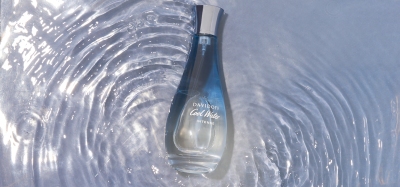 Fragrance shot of a perfume bottle on rippling water. By Nick van der Touw.