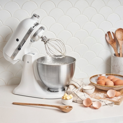 Product shot of a stand mixer with a whisk and eggs. By Nick van der Touw.