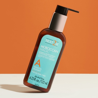 Product shot of a Moroccan argan oil hair product on orange. By Nick van der Touw.