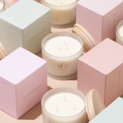Anke candle in a glass jar with pink gift boxes. By Nick van der Touw.