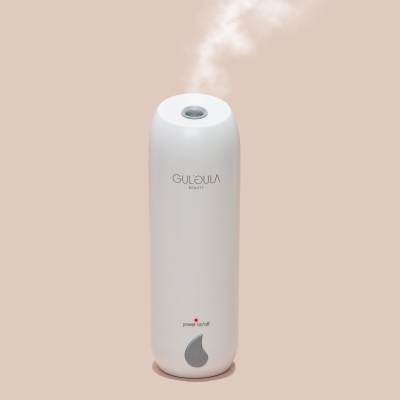 Product shot of a white humidifier emitting steam. By Nick van der Touw.