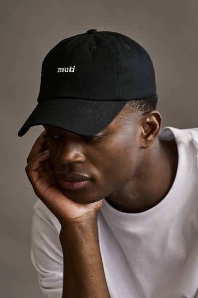 Muti Collection One 2022 campaign frame featuring a styled cap. Fashion photography by Nick van der Touw.