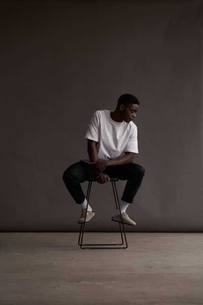 Muti Collection One 2022 campaign frame seated on a stool. Fashion photography by Nick van der Touw.