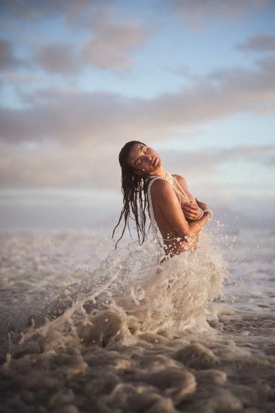 Editorial of Albina draped in pearls, photographed inside a breaking wave. By Nick van der Touw.
