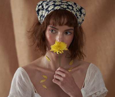 Editorial portrait of Franchesca with a single daisy. Studio photography by Nick van der Touw.