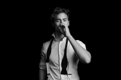 Editorial portrait of Ross smoking, lit by hard sidelight. Studio photography by Nick van der Touw.